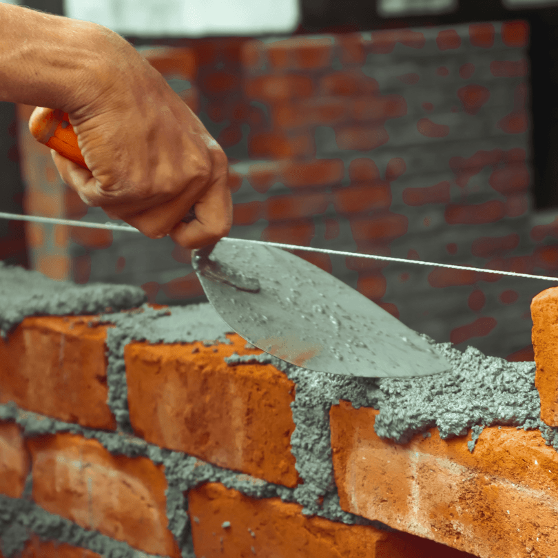 Alvenaria e acabamentos em obra, representativa de construção tradicional com enfoque sustentável.